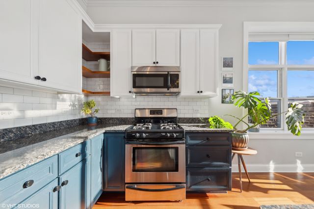 a kitchen with appliances a stove and cabinets