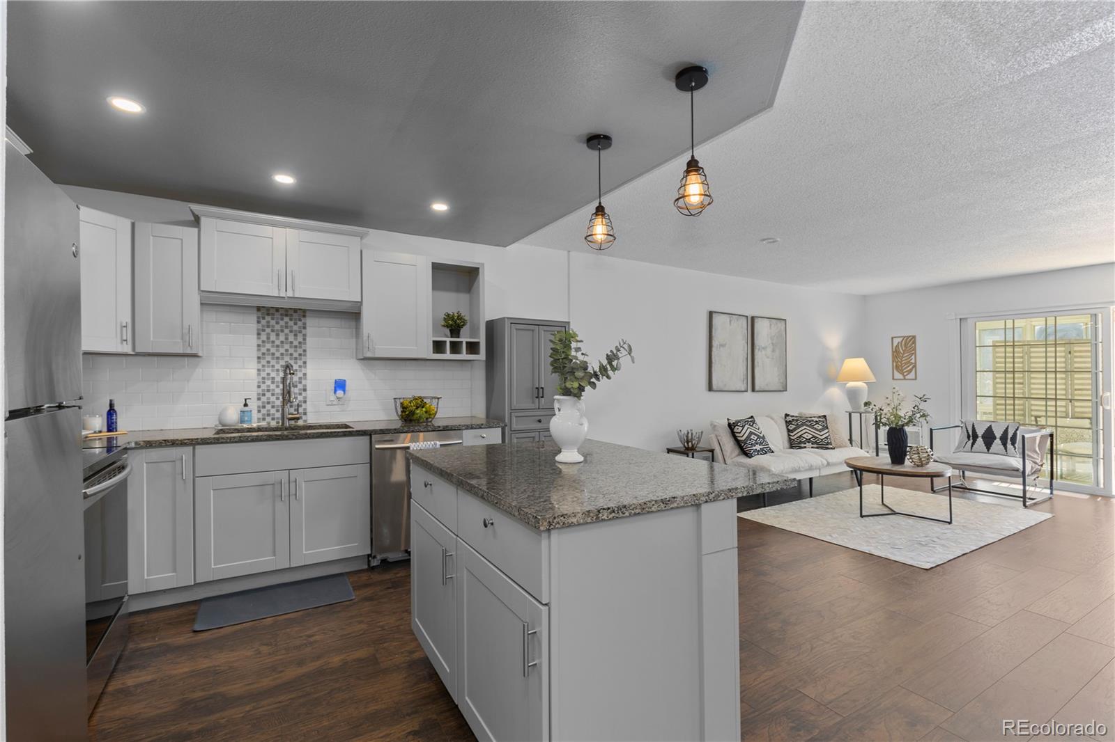 610 South Clinton Street, Unit 10A Denver, CO 80247 - Photo 37 of 40 a kitchen with granite countertop a sink a counter top space appliances and cabinets