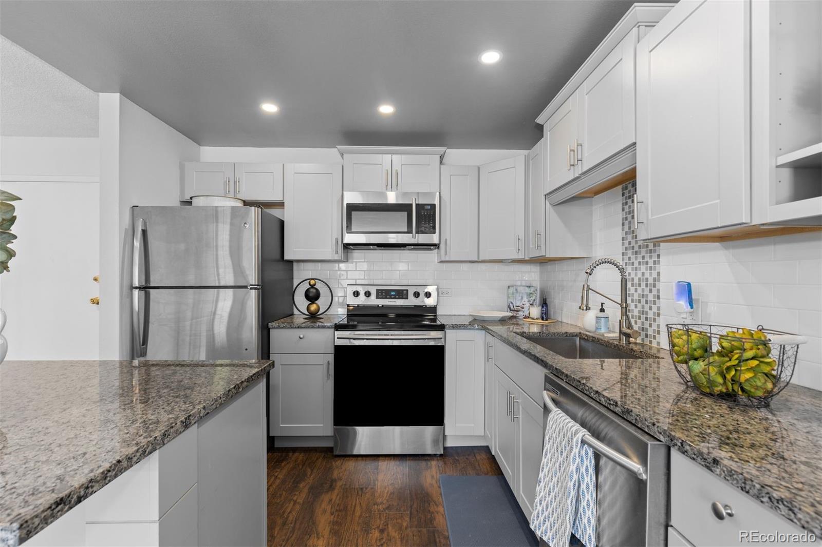 610 South Clinton Street, Unit 10A Denver, CO 80247 - Photo 8 of 40 a kitchen with stainless steel appliances granite countertop a sink stove and refrigerator
