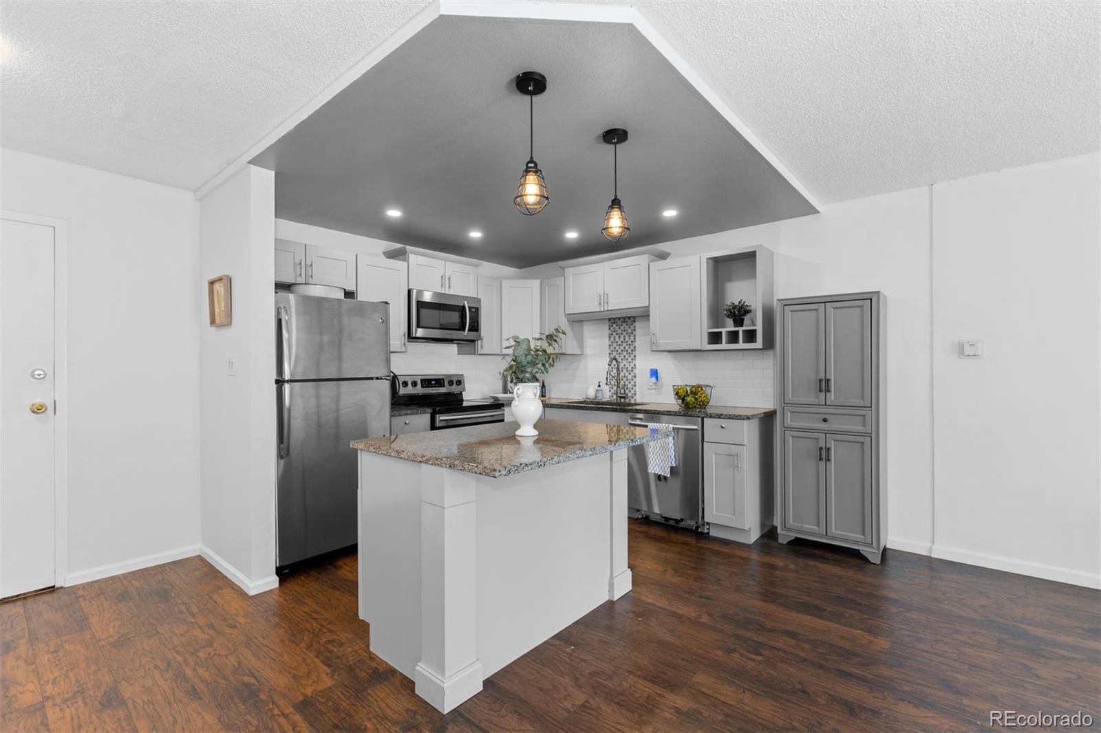 610 South Clinton Street, Unit 10A Denver, CO 80247 - Photo 10 of 40 a kitchen with stainless steel appliances granite countertop a refrigerator a sink dishwasher a stove top oven a refrigerator and white cabinets with wooden floor