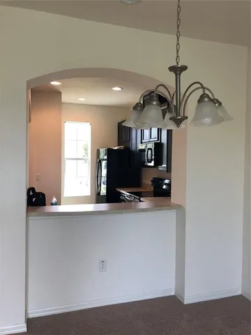 a room with a chandelier and fireplace