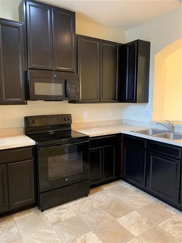 a kitchen with granite countertop a refrigerator and a sink