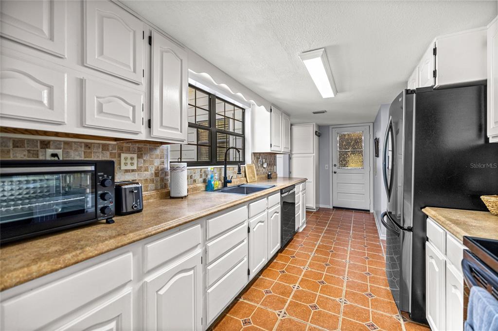 10245 Southwest 105th Street Ocala, FL 34481 - Photo 19 of 83 a kitchen with stainless steel appliances granite countertop a refrigerator a oven and white cabinets
