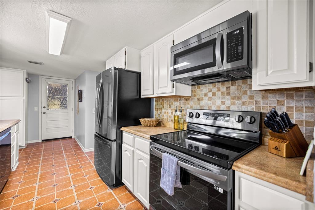 10245 Southwest 105th Street Ocala, FL 34481 - Photo 20 of 83 a kitchen with stainless steel appliances granite countertop a stove microwave refrigerator and sink