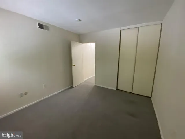 a view of an empty room with cabinet and a window