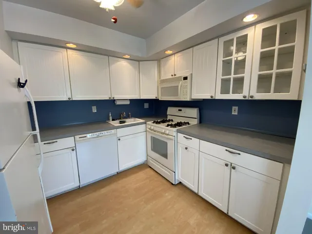 a kitchen with cabinets appliances a sink and a window