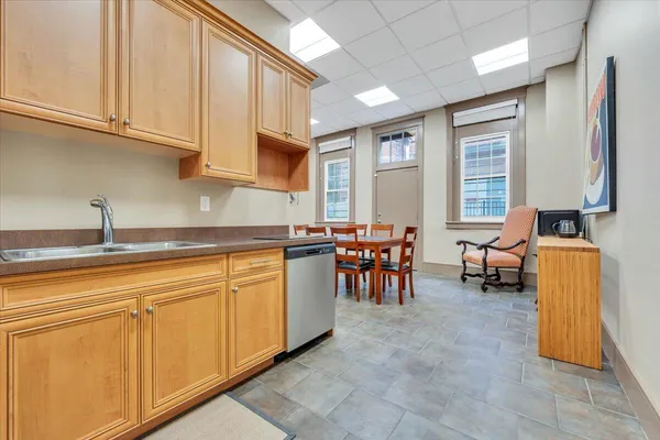 a kitchen with sink a chair and glass door