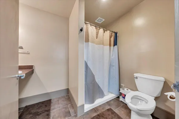 a white toilet sitting next to a shower