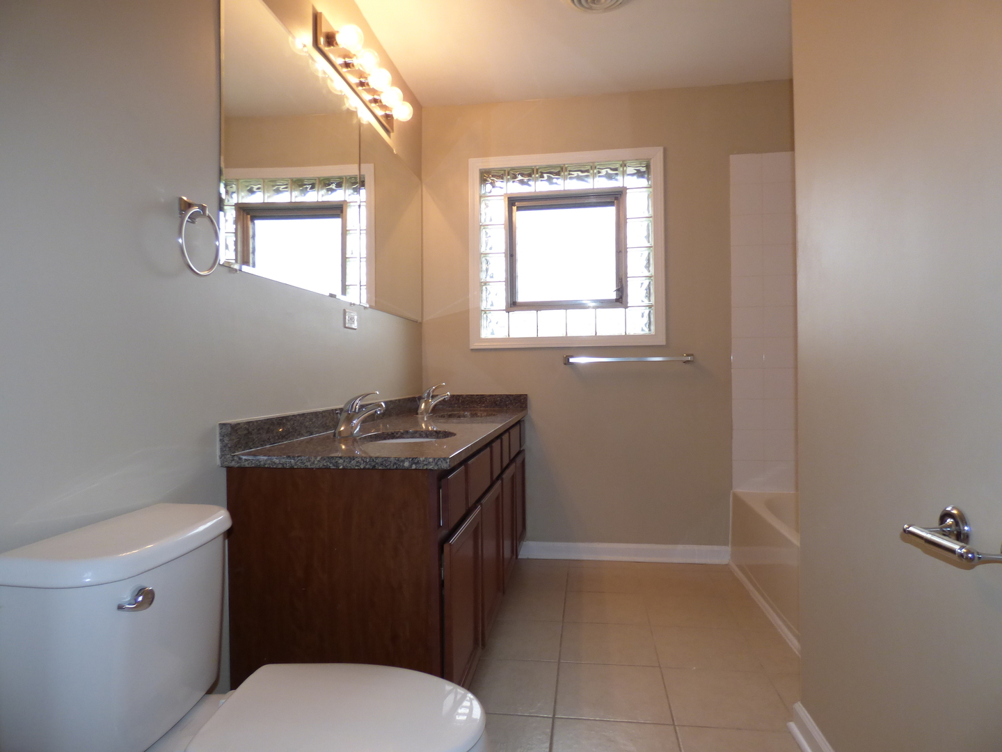 4N261 7th Avenue Addison, IL 60101 - Photo 21 of 31 a bathroom with a granite countertop toilet a sink and a mirror