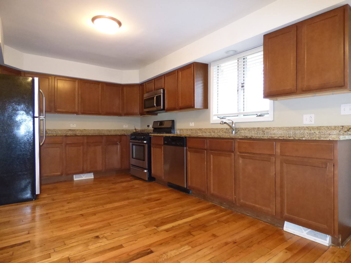 4N261 7th Avenue Addison, IL 60101 - Photo 5 of 31 a kitchen with stainless steel appliances granite countertop a sink and cabinets with wooden floor