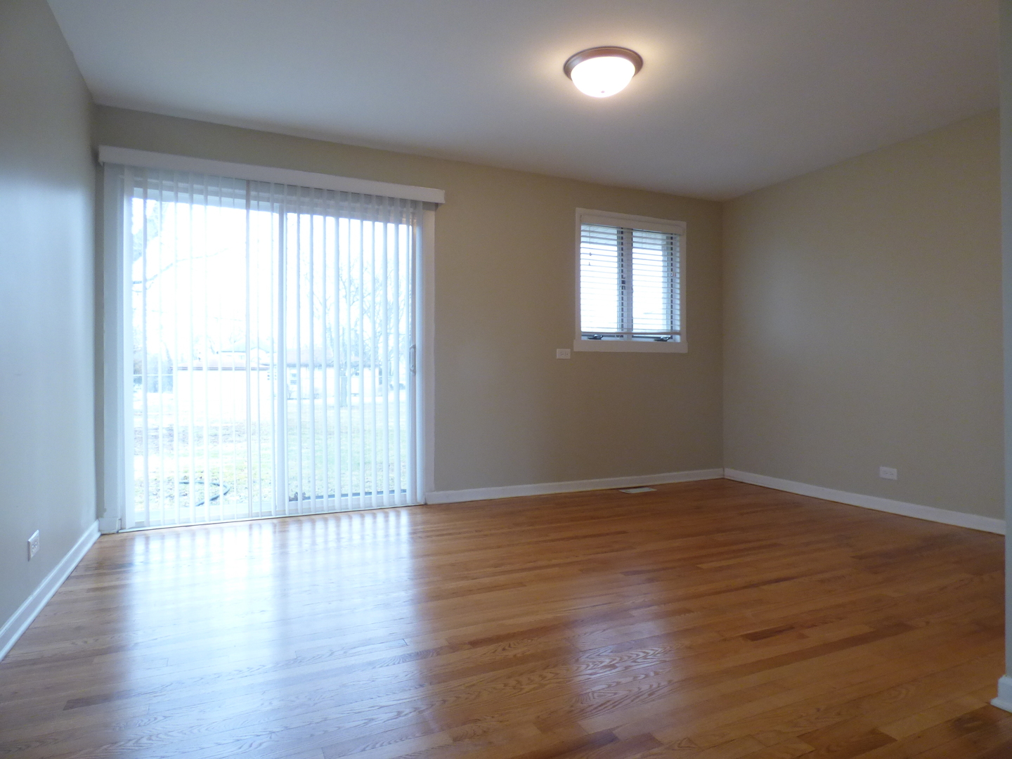 4N261 7th Avenue Addison, IL 60101 - Photo 8 of 31 a view of an empty room with wooden floor and a window