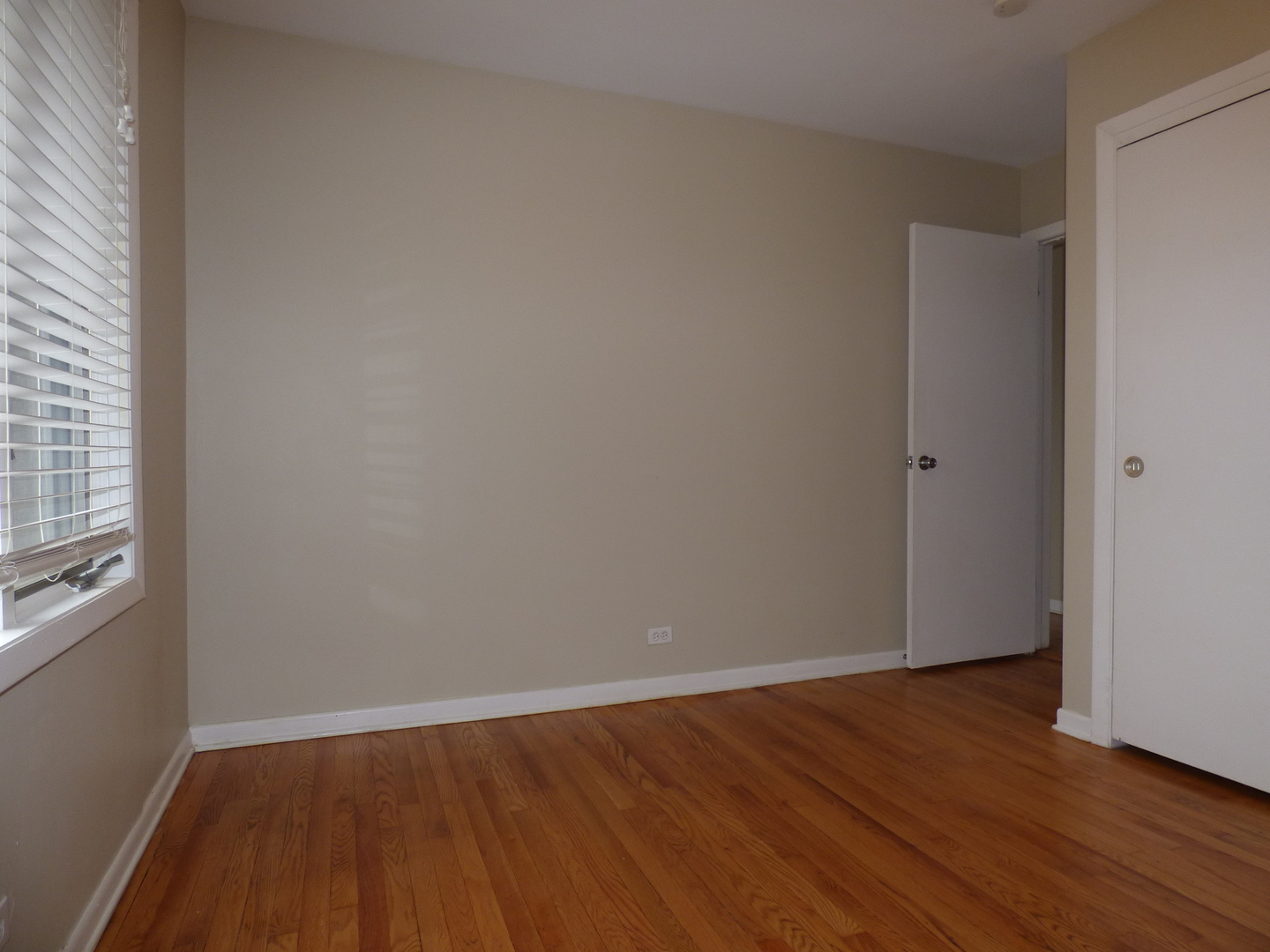 4N261 7th Avenue Addison, IL 60101 - Photo 10 of 31 a view of an empty room with wooden floor and a window