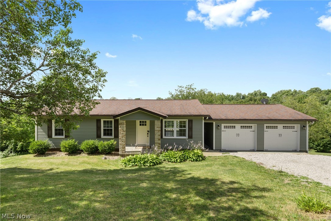 Ranch-style home featuring a garage and a front yard