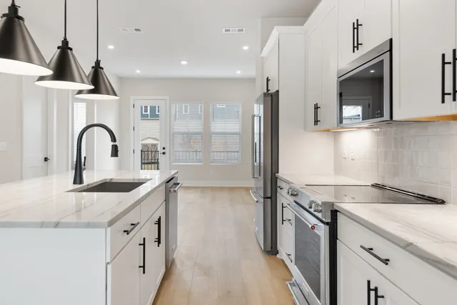a kitchen with stainless steel appliances granite countertop a sink and a refrigerator