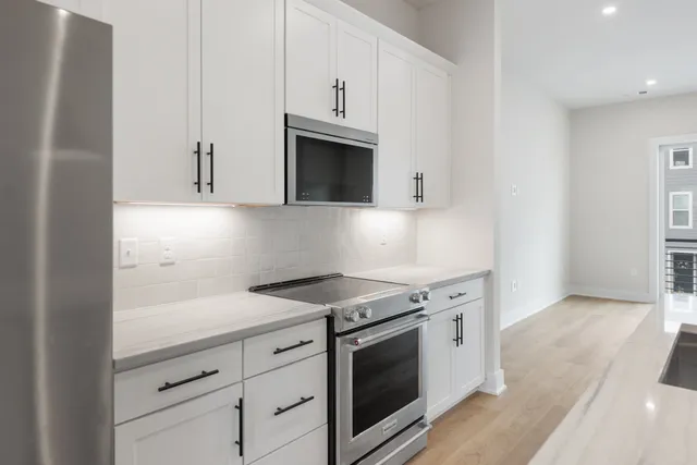 a kitchen with granite countertop white cabinets and white appliances