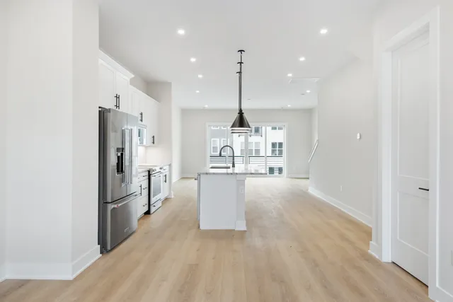 a kitchen with stainless steel appliances granite countertop a refrigerator and a sink