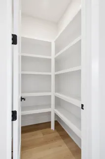 a view of walk in closet with empty racks