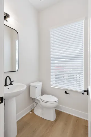 a bathroom with a toilet a sink and mirror