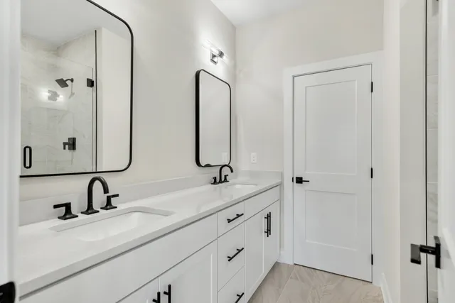 a bathroom with 2 sink and a mirror