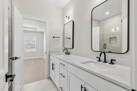 a bathroom with a double vanity sink double mirror and bathtub