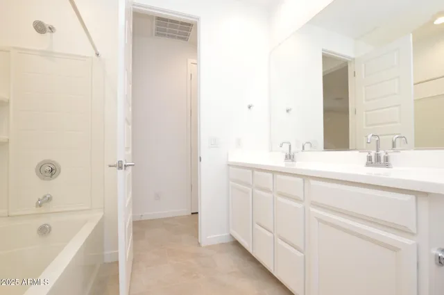 a bathroom with a tub sink and mirror