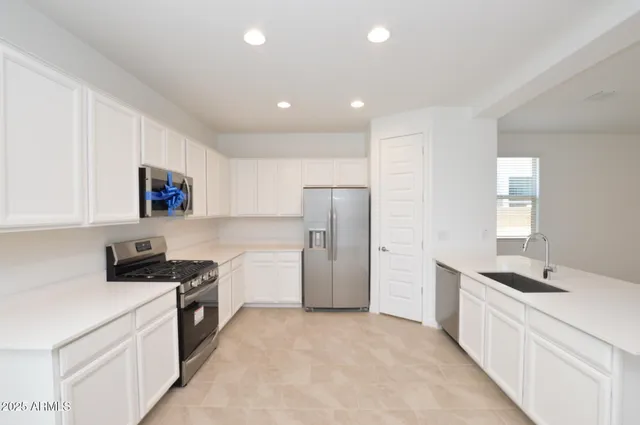 a kitchen with a sink a refrigerator and cabinets