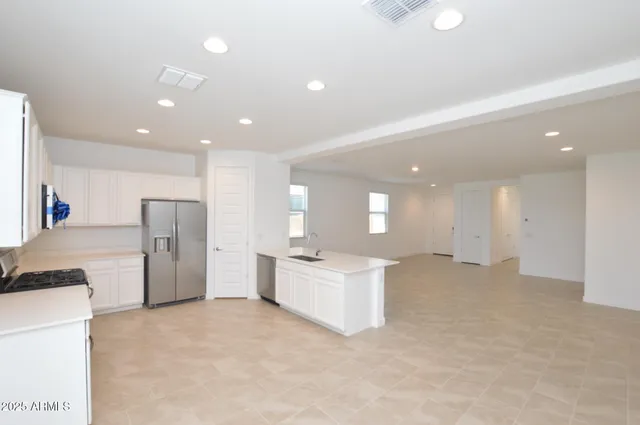 a kitchen with stainless steel appliances a refrigerator sink and cabinets