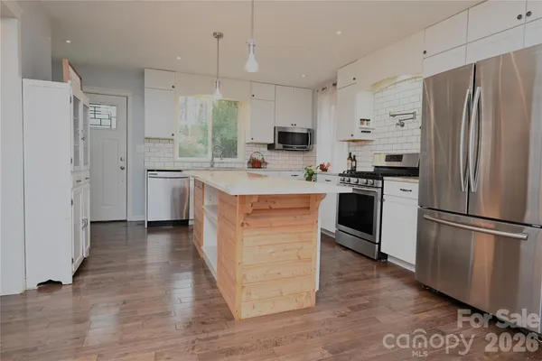 a kitchen with stainless steel appliances a refrigerator sink and stove