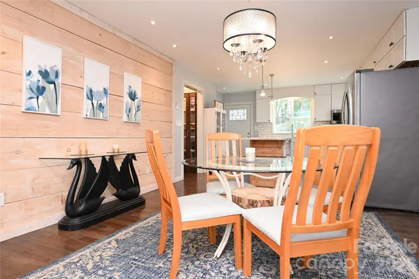 a dining room with furniture a chandelier and wooden floor