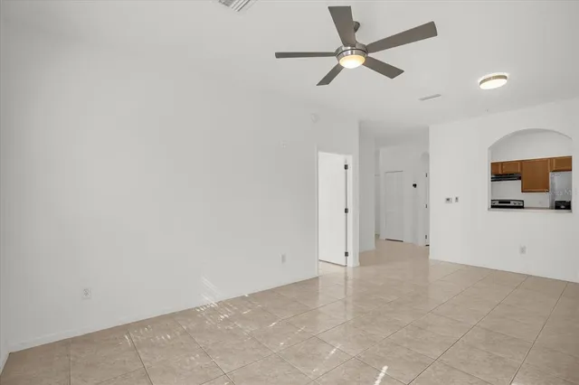 an empty space with a ceiling fan and a bathroom