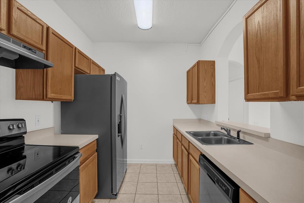 13500 Turtle Marsh Loop, Unit 811 Orlando, FL 32837 - Photo 6 of 23 a kitchen with stainless steel appliances granite countertop a sink stove and refrigerator