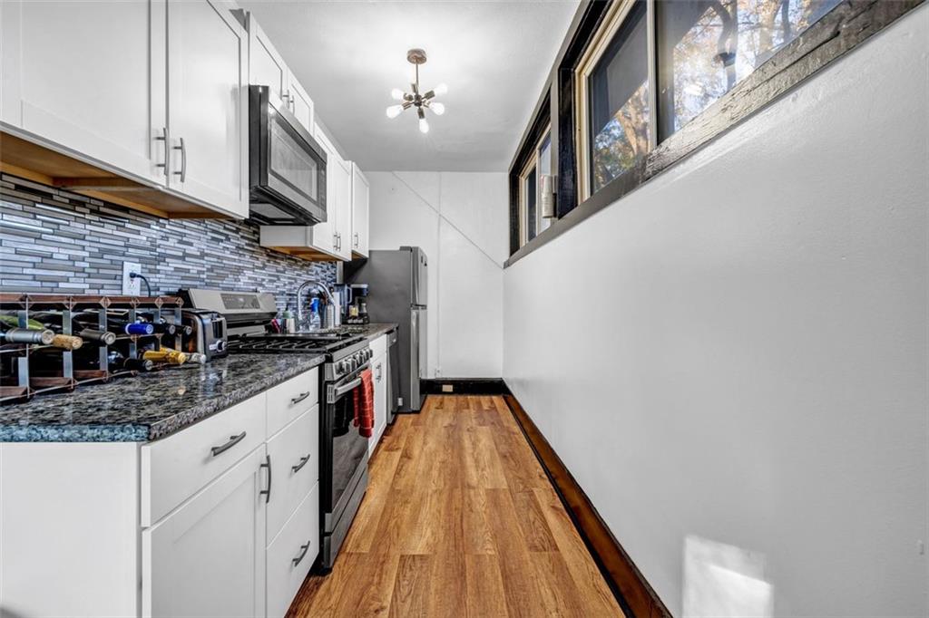 800 Myrtle Street Northeast Atlanta, GA 30308 - Photo 13 of 28 a kitchen with stainless steel appliances granite countertop a sink and dishwasher a stove top oven with wooden floor