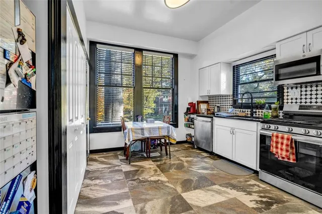 a kitchen with stainless steel appliances granite countertop a stove a sink and a refrigerator