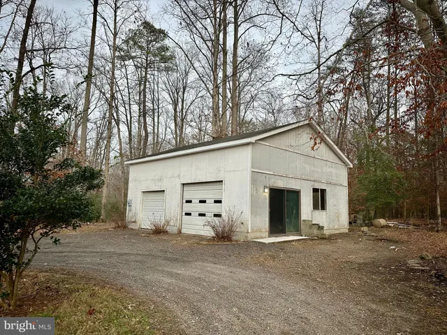 a view of a white house with a yard and garage