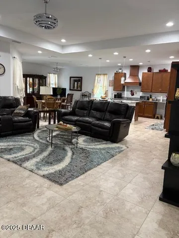 a living room with furniture and view of kitchen