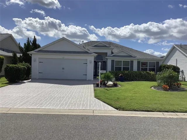 a front view of a house with a garden and yard