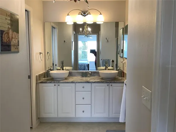 a bathroom with granite countertop a sink and a mirror