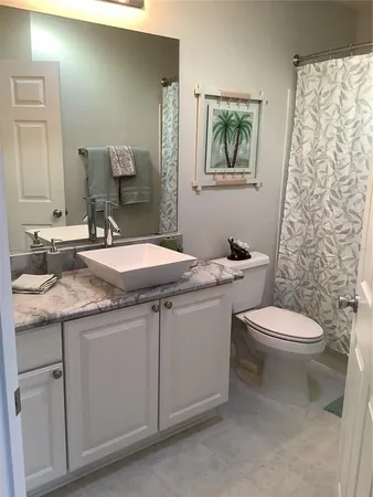 a bathroom with a granite countertop toilet sink and mirror