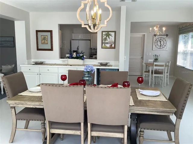 a dining room with a table chairs and kitchen view