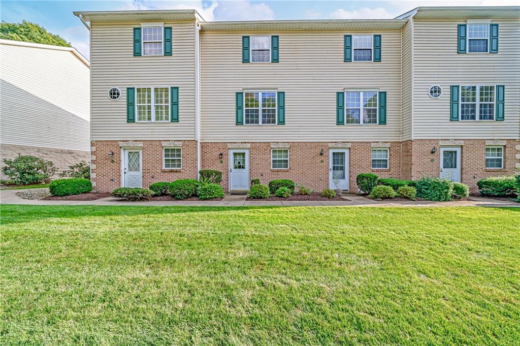 a front view of house with yard and green space