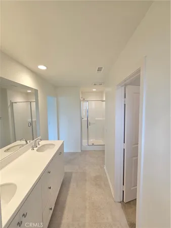 a spacious bathroom with a double vanity sink and a mirror