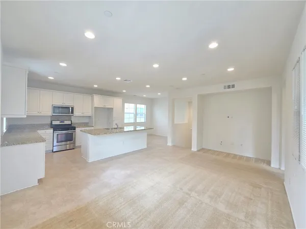 a view of kitchen with kitchen island and stainless steel appliances