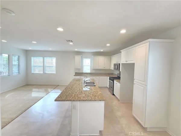 a kitchen with stainless steel appliances granite countertop a refrigerator sink and cabinets