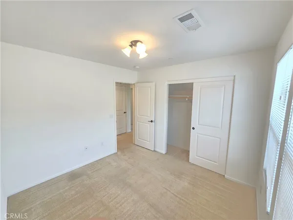 a view of an empty room and a ceiling fan