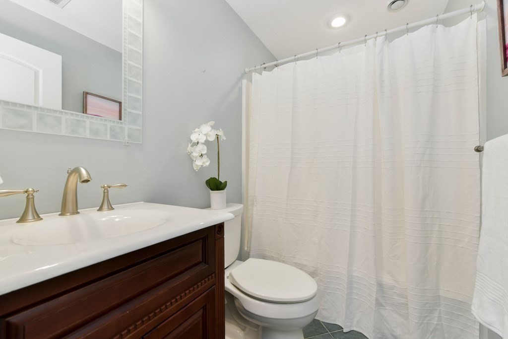 16 Burr Road Hull, MA 02045 - Photo 17 of 25 a bathroom with a sink a toilet and shower curtain