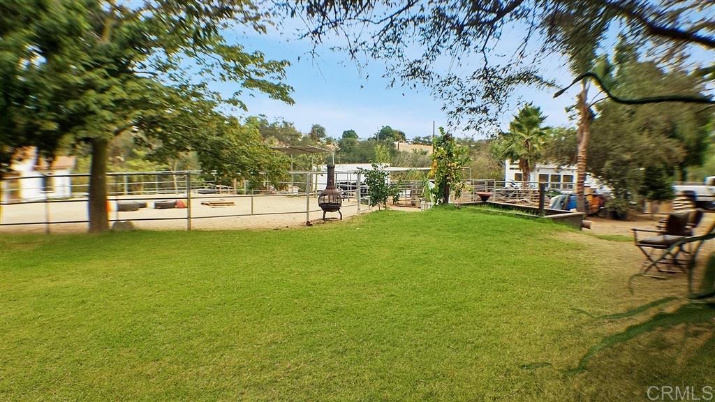 1022 El Caminito Road Fallbrook, CA 92028 - Photo 6 of 17 Lush green lawn for a game of catch or fetch or just hang by the chiminea with family and friends. 60ft round arena in background along with raised bed garden and mature fruit trees. Lofted garden shed could be potential aux dwelling? Zoned RR2 split-able