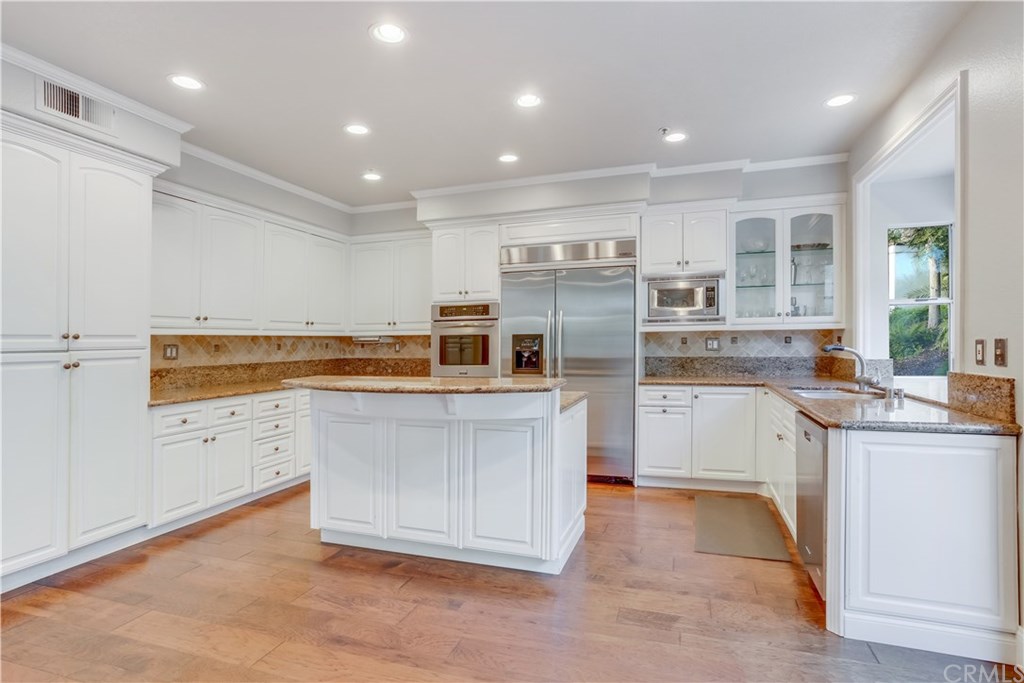6 Via Colorso San Clemente, CA 92672 - Photo 8 of 32 Bright white cabinetry, with granite countertops, stainless steel appliances, and hardwood flooring. Kitchen opens up to living room. Lots of natural light!