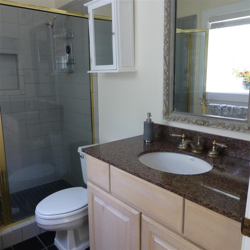 6859 Neshoba Road Memphis, TN 38120 - Photo 16 of 24 Private Master Bath has updated tile flooring, newer cabinetry with granite counter tops & large walk in shower.
