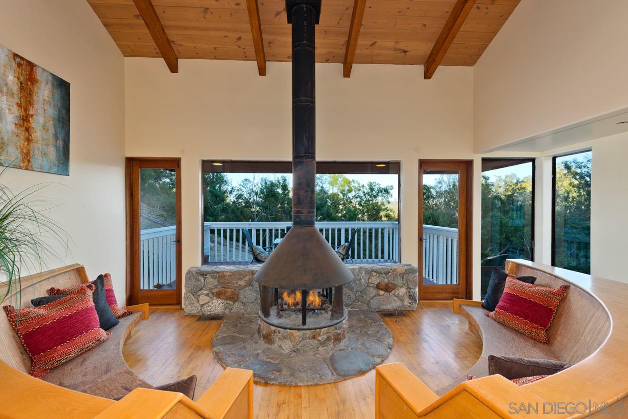 5404 Las Palomas Rancho Santa Fe, CA 92067 - Photo 8 of 25 Fantastic cozy sitting areas with bench seating around the wood burning stove, and access to downstairs maid's quarter or attached guest quarters that has its own outside access