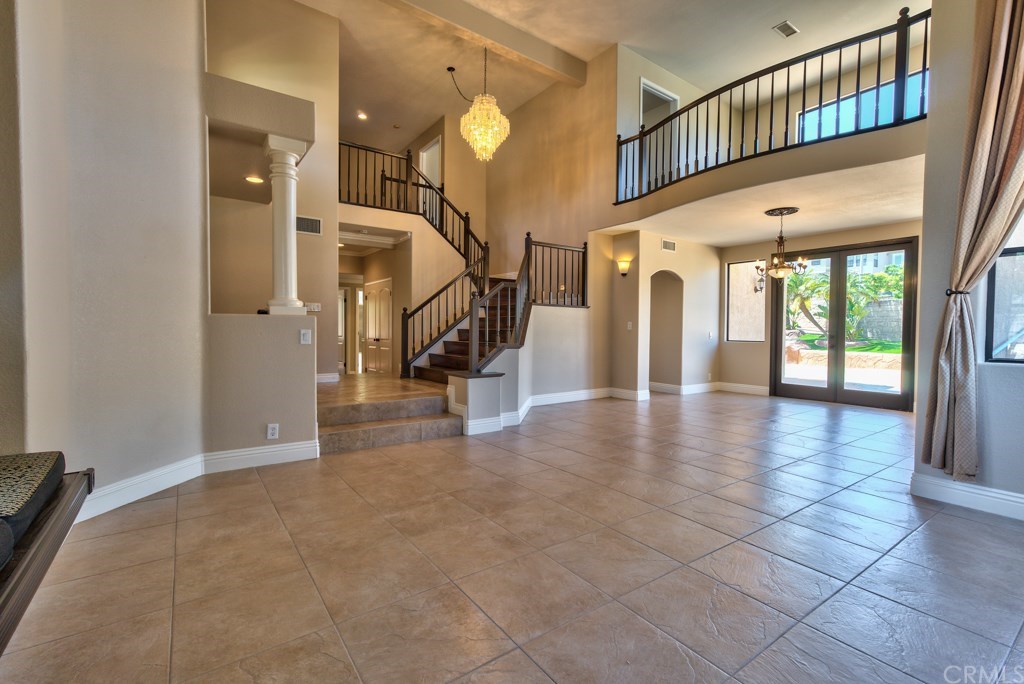 3086 Diamondview Circle Corona, CA 92882 - Photo 6 of 66 Views of the expansive living and dining area that has oversized tile floors throughout. The new interior paint encompasses the entire house. The room with the railing on the 2nd floor is the master retreat.